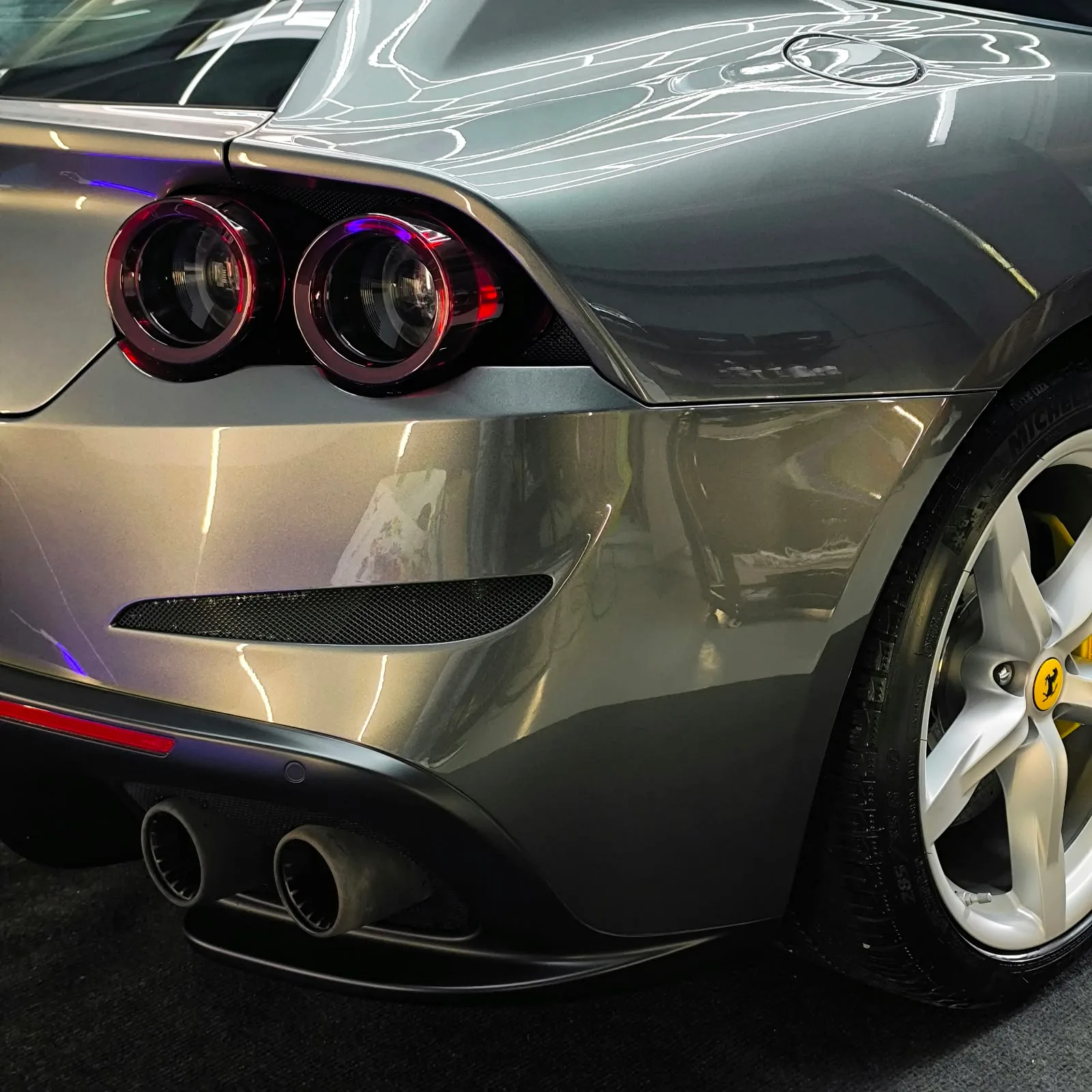 Heckansicht eines grauen Ferrari 812 Superfast mit vier Endrohren