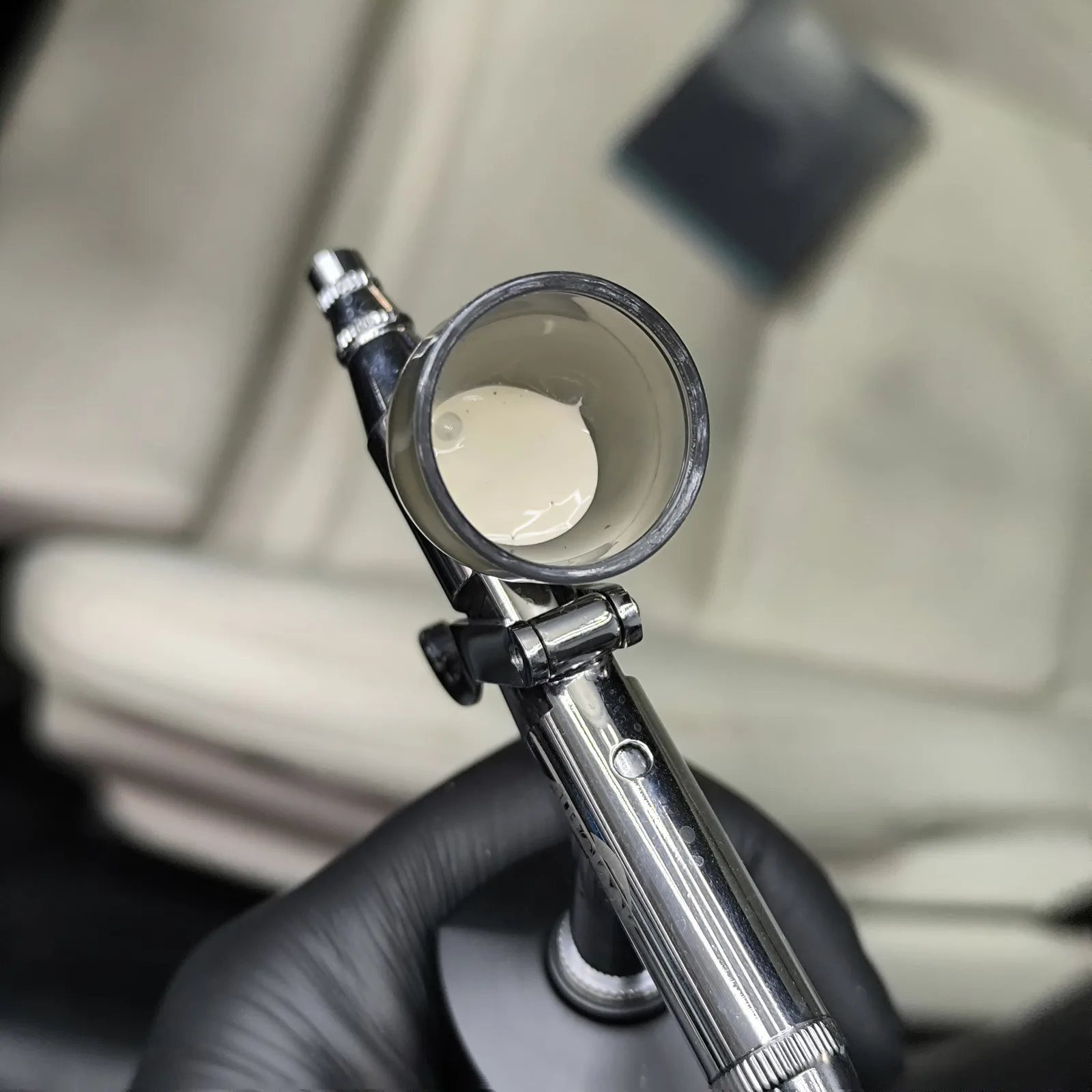 Airbrush-Pistole gefüllt mit beigefarbener Lederfarbe
